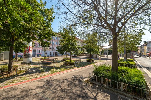 Platz mit Sitzmöglichkeiten und Bäumen